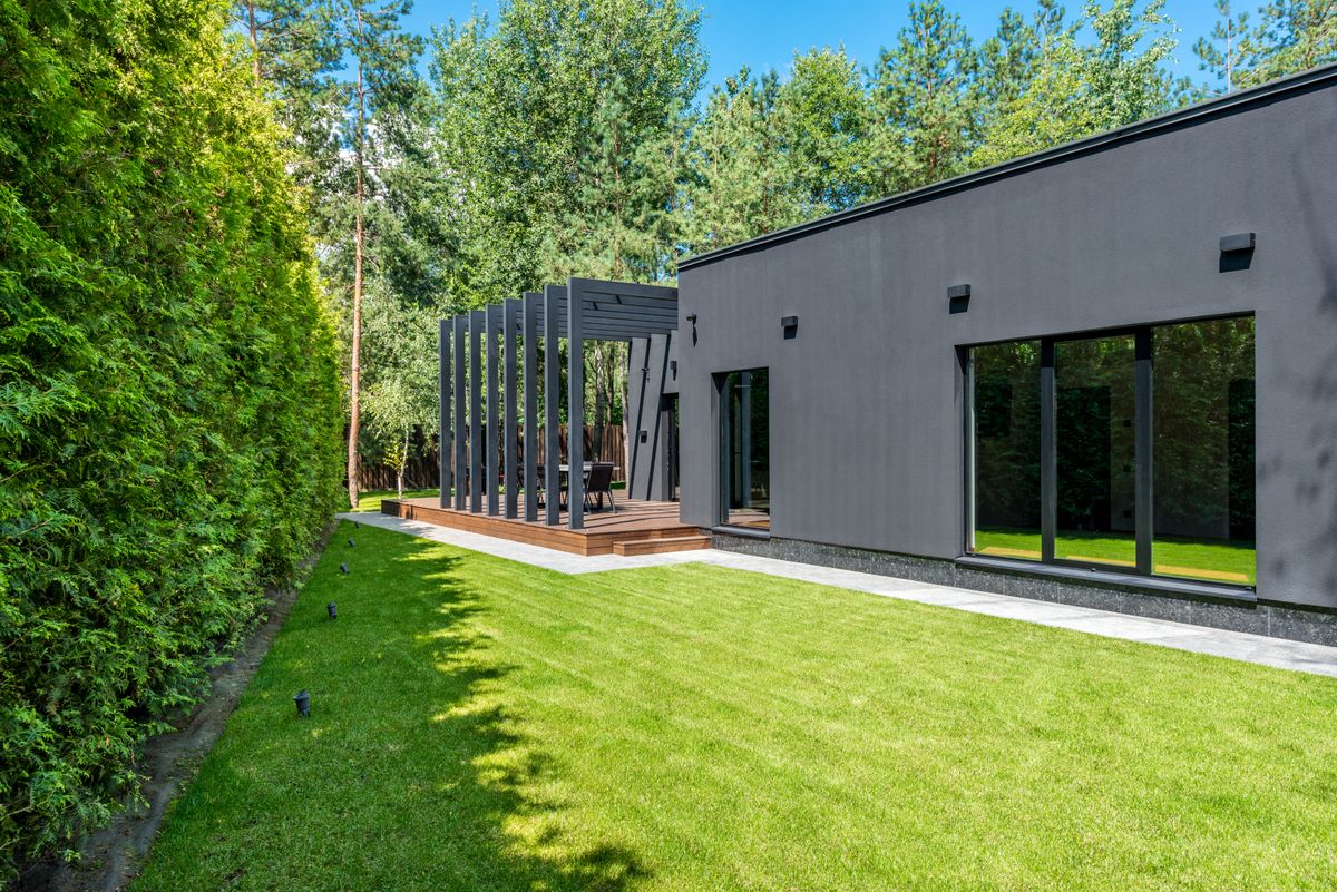 A modern house with a wooden deck and maintained lawn
